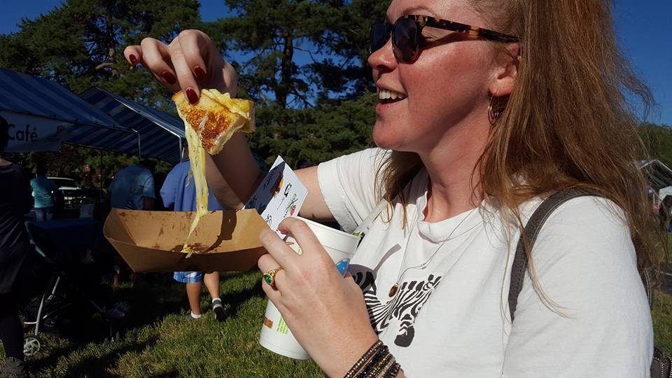 Festival guest enjoying a slice of pizza outdoors