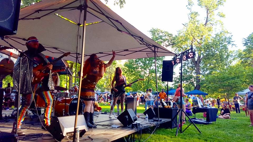 Live band playing under a tent at an outdoor festival